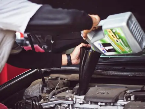homem reabastecendo óleo do motor no compartimento